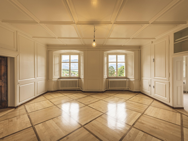 Altbauwohnung mit Stuck an der Decke und den Wänden, 2 Fenster mit Blick auf Bäume und Berge