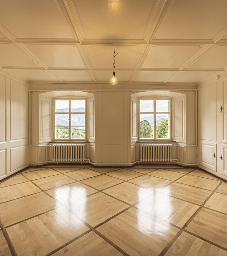 Altbauwohnung mit Stuck an der Decke und den Wänden, 2 Fenster mit Blick auf Bäume und Berge