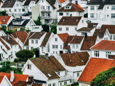 Viele weiß gestrichene Häuser mit roten Dächern an einem Hang
