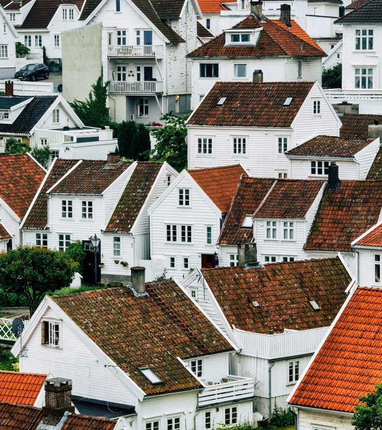 Viele weiß gestrichene Häuser mit roten Dächern an einem Hang