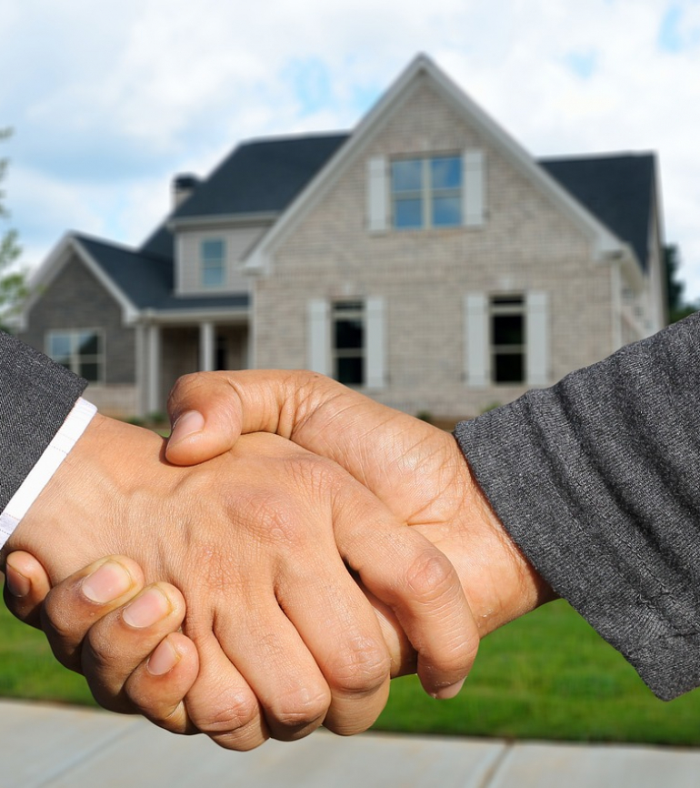Handschlag vor einem Haus