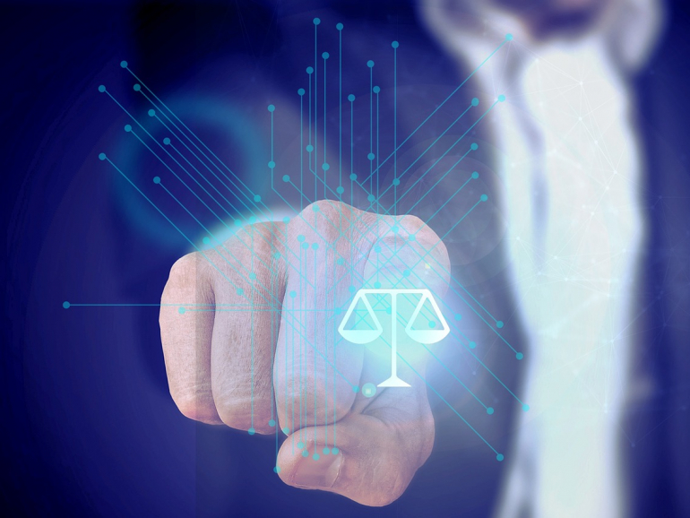 Hand klickt auf fiktiven Button mit einer Waage, die für Justiz steht